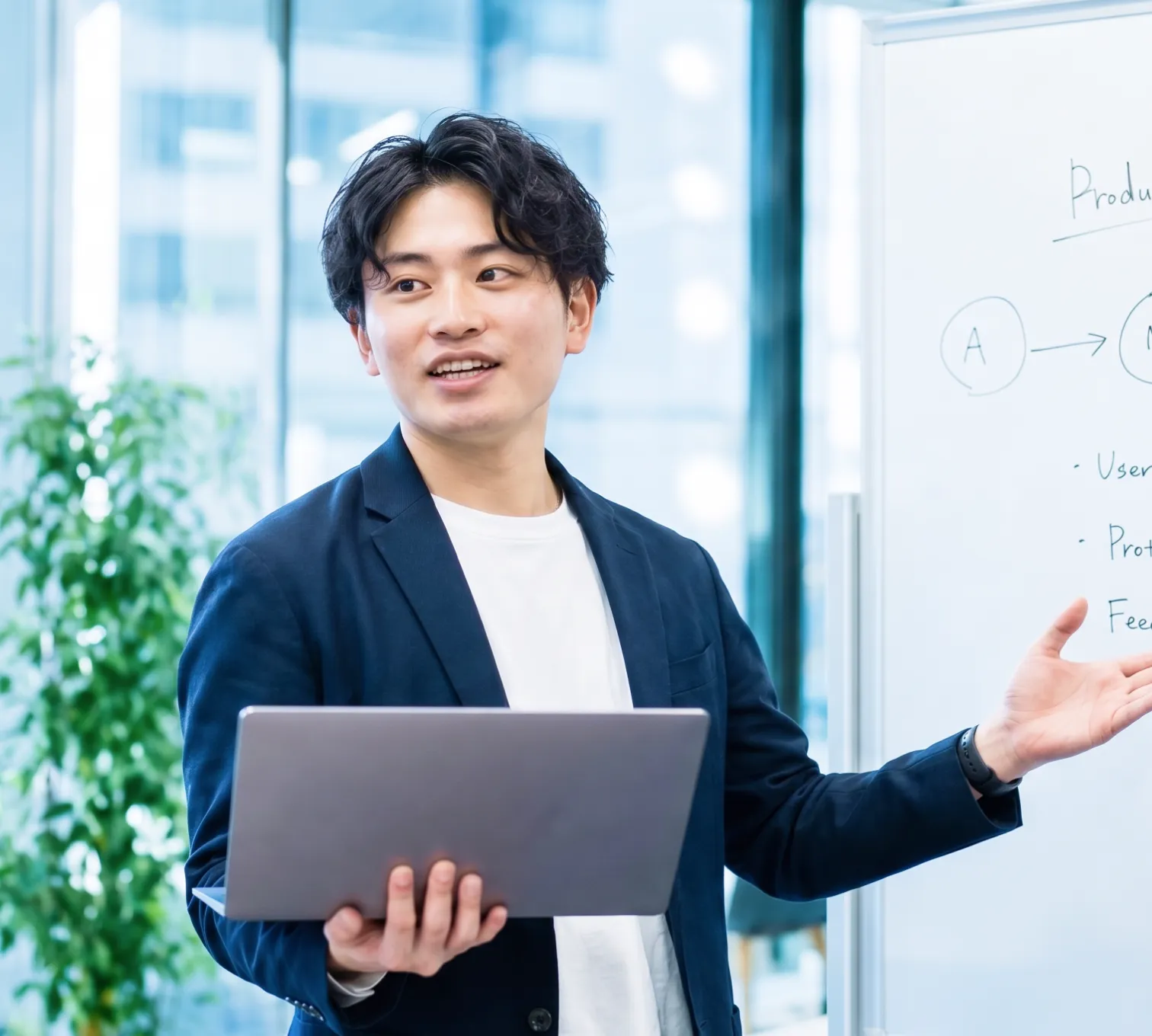 ホワイトボードの前で説明する男性社員