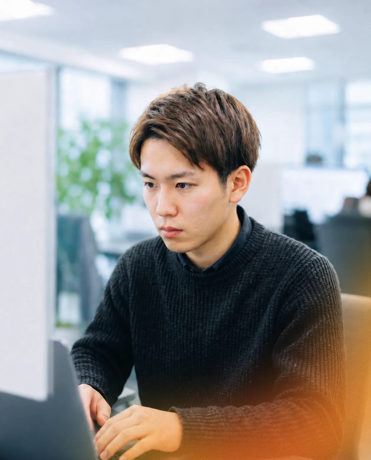 モニターに向かって作業する男性社員